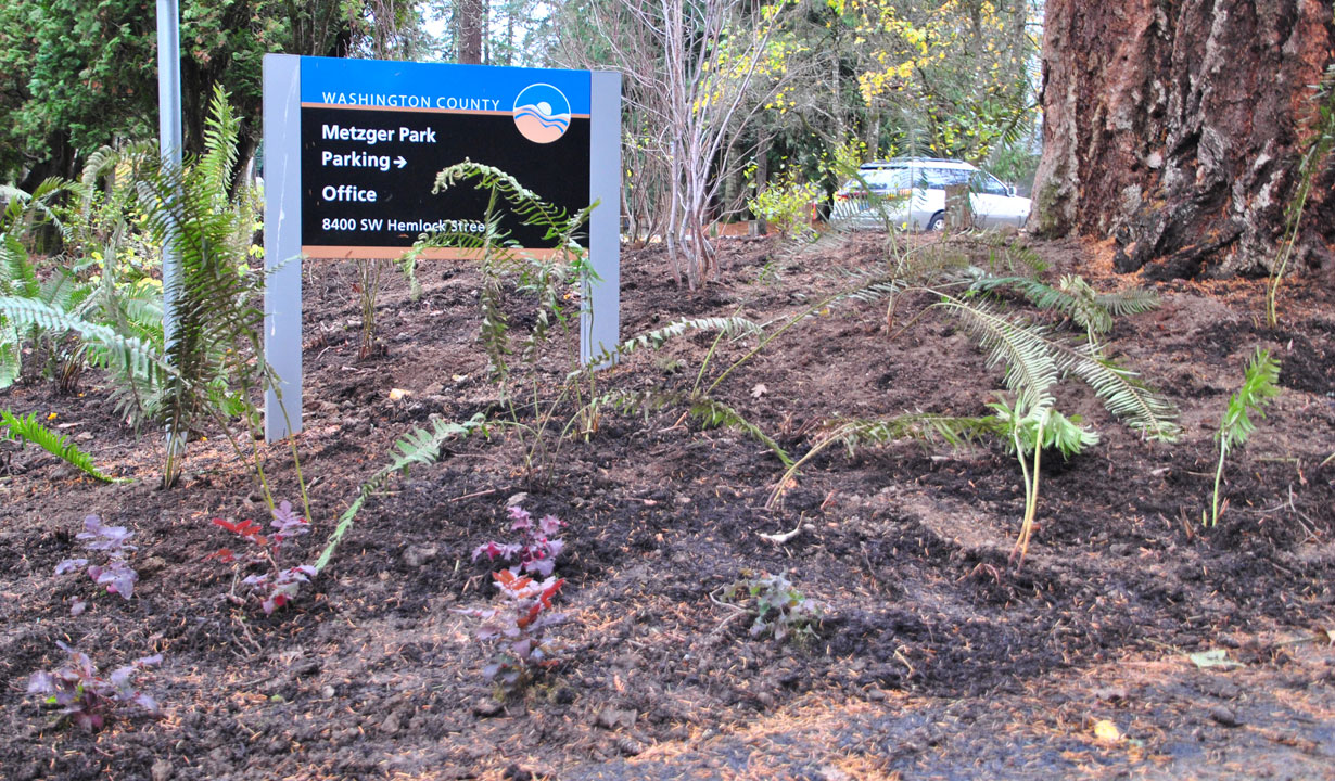 Garden planted with native plants at Metzger Park with the park sign in the background.